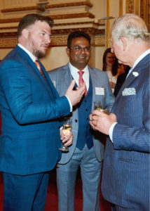 Dr Sudesh Fernando and Thomas Ogden in animated conversation with the former Prince of Wales - now King Charles III